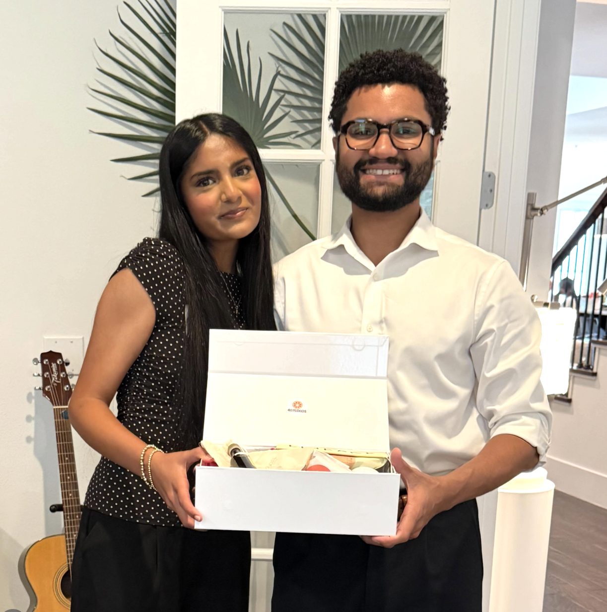 Two people holding an open 407Goods gift box filled with products from local makers